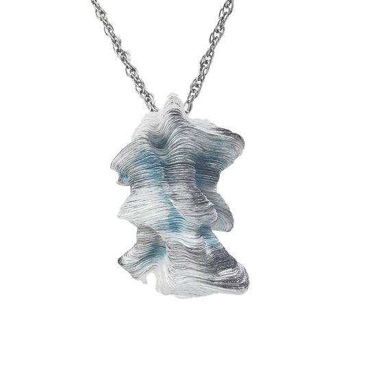 A blue and white striped pendant featuring a textured, organic shape, attached to a stainless steel chain. Blue Laser Cut,  Inked, and Stacked Tyvek Pendant Necklace on a Steel Chain