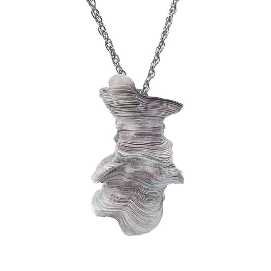 A laser-cut Tyvek paper pendant with a stainless steel neck cord, featuring shades of purple and blue.