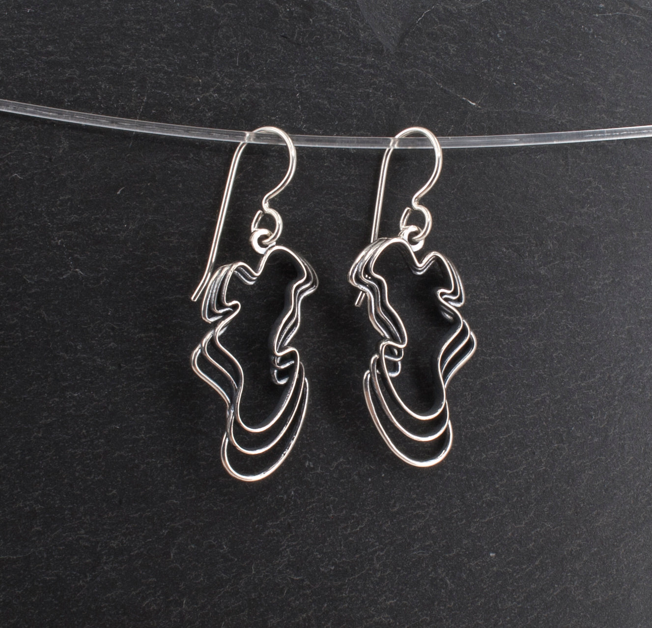 Sterling Water Waves Curvy Earrings on a Slate Background